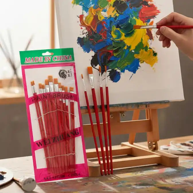 a pack of paint brushes and a hand painting on a canvas with one of the brushes