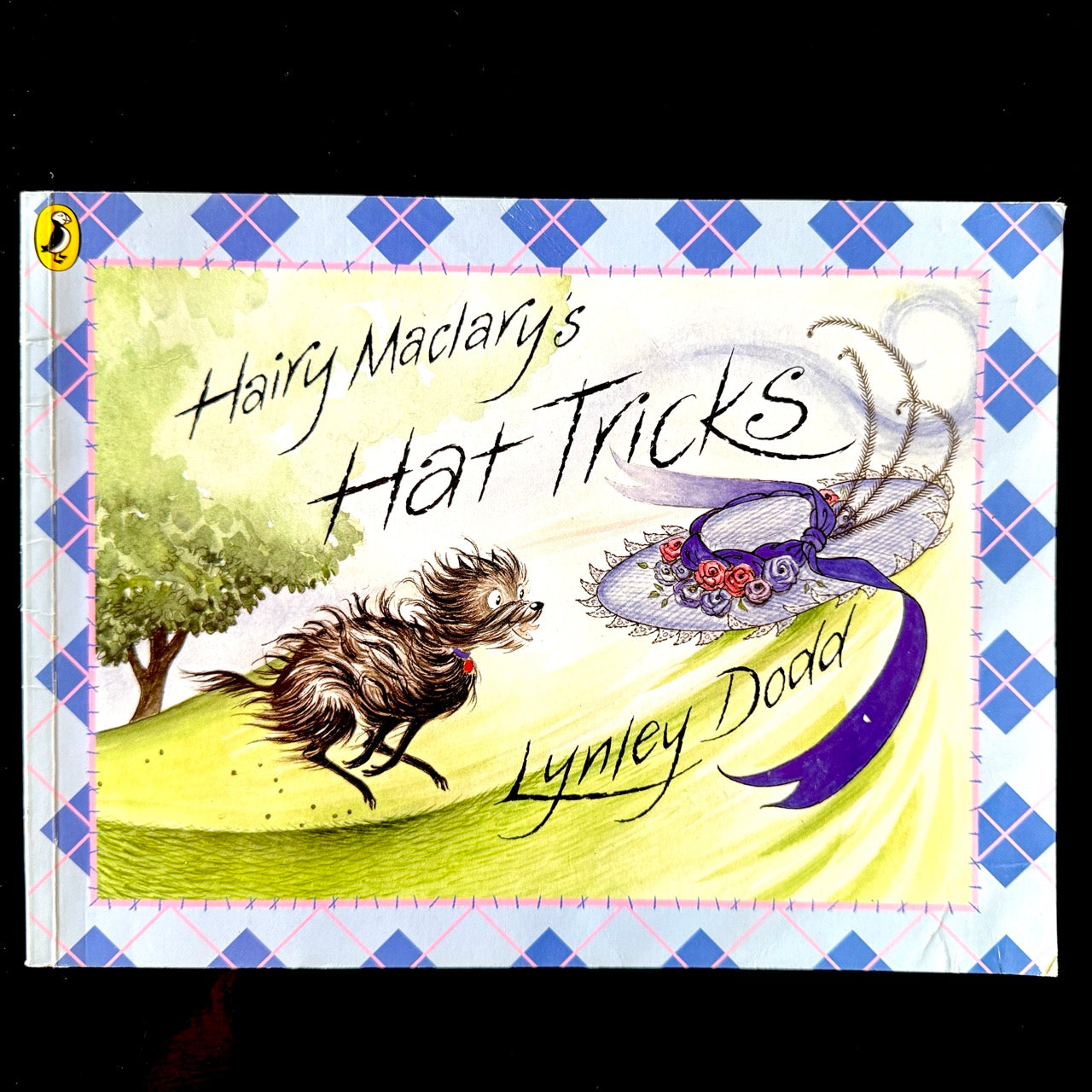 Book cover of 'Hairy Maclary's Hat Tricks' by Lynley Dodd with a dog and hat illustration.