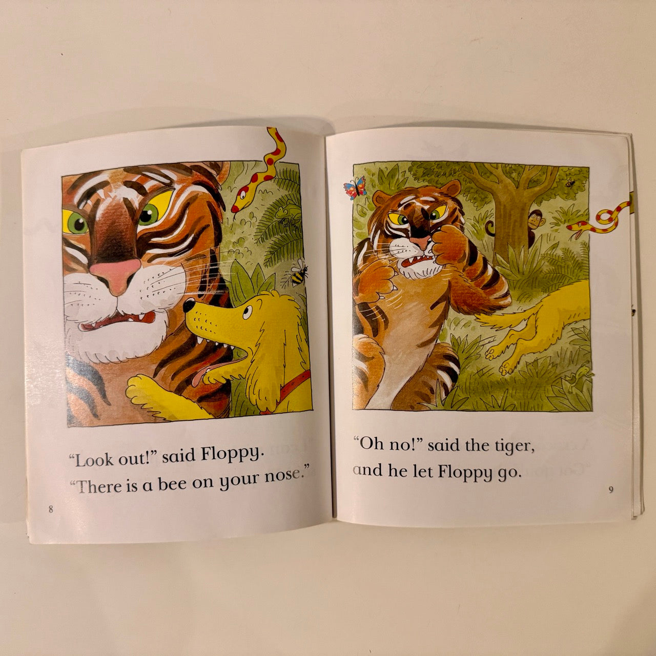 Open book with illustrations of a tiger and a dog in a jungle setting