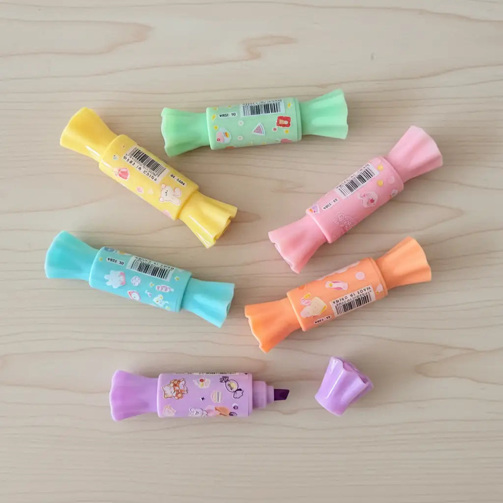 Colorful markers with cartoon designs on a wooden surface
