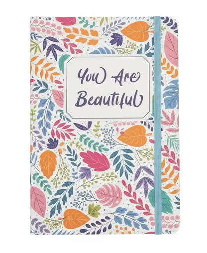 Notebook with colorful leaf pattern and 'You Are Beautiful' text on a white background