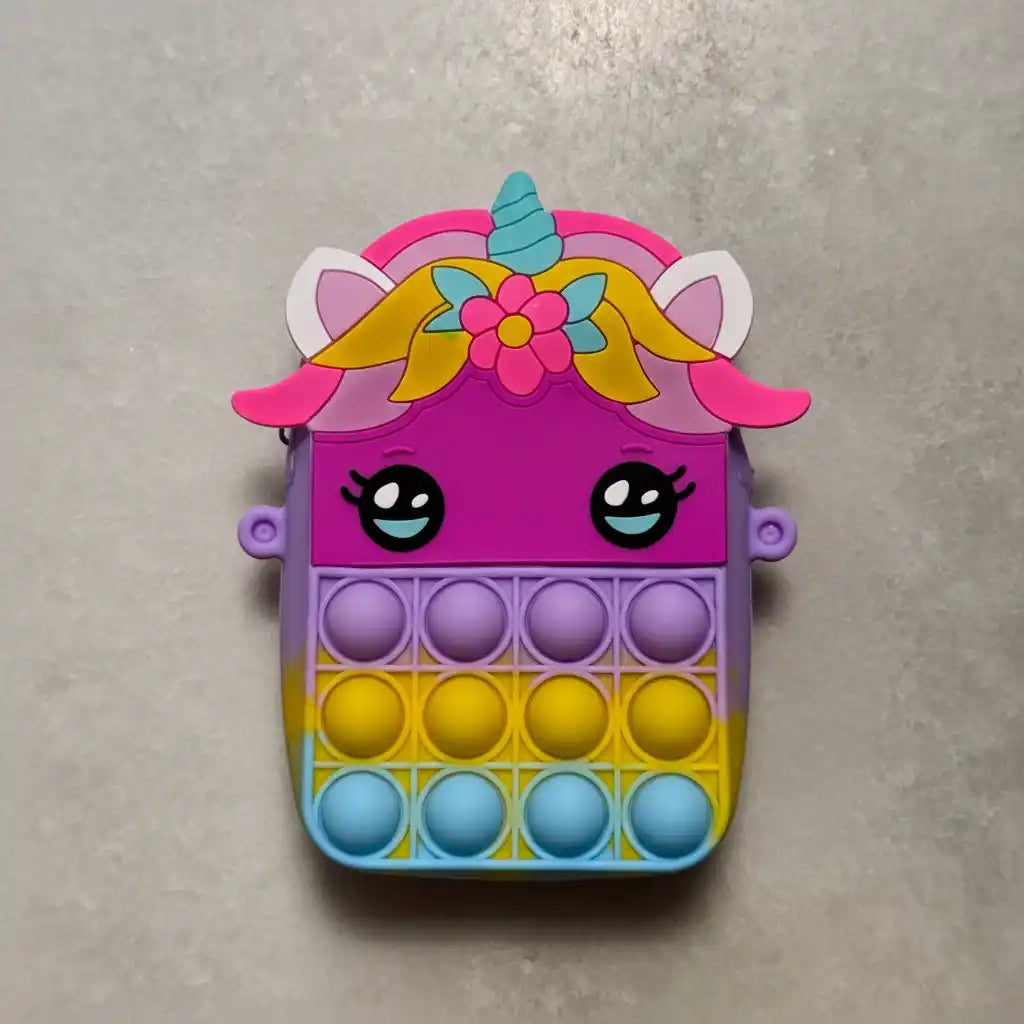 Colorful unicorn-shaped pop-it fidget toy on a gray background
