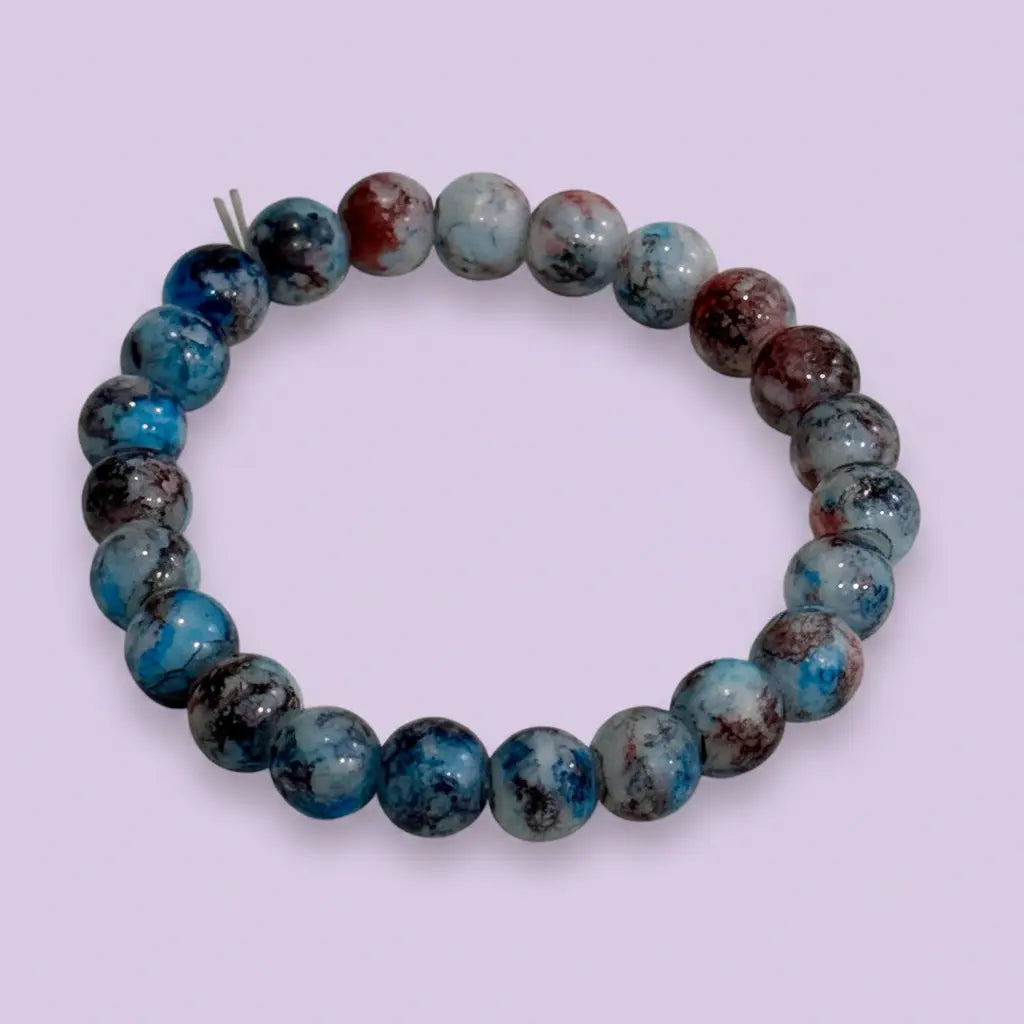 Round beaded bracelet with blue and brown marbled pattern on a light purple background