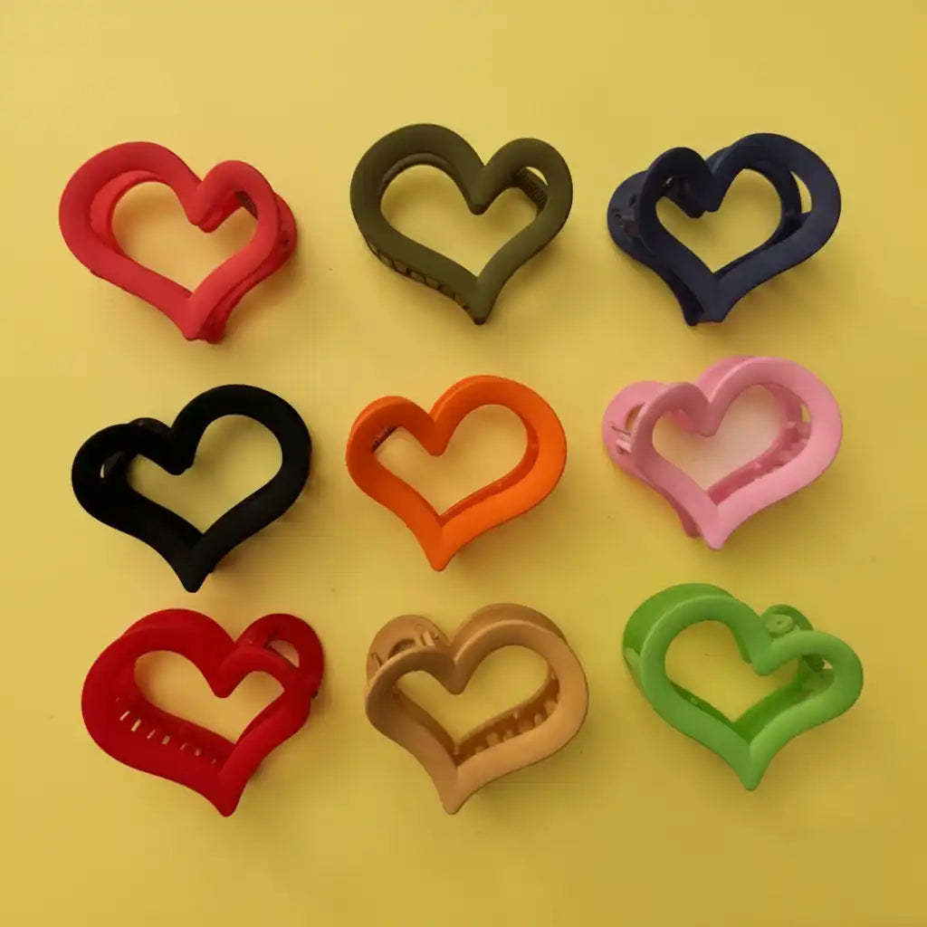 Heart-shaped cookie cutters in various colors on a yellow background