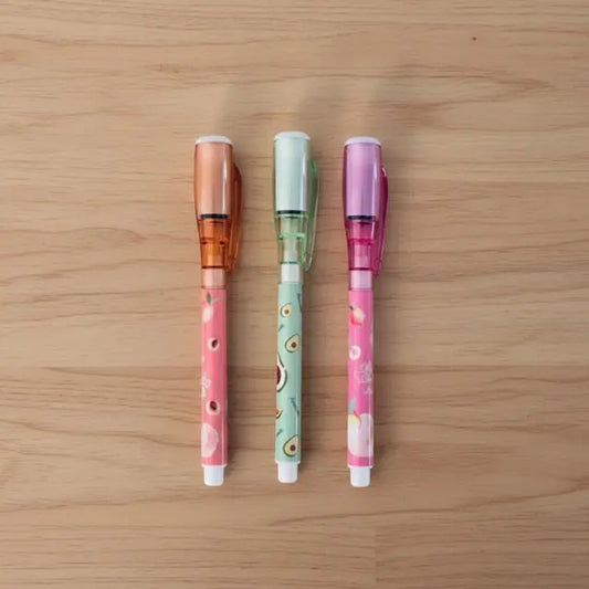 Three colorful pens on a wooden surface