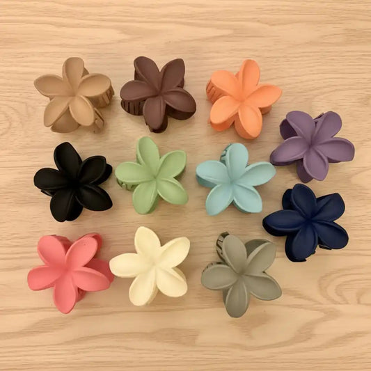 Colorful flower-shaped hair clips on a wooden surface