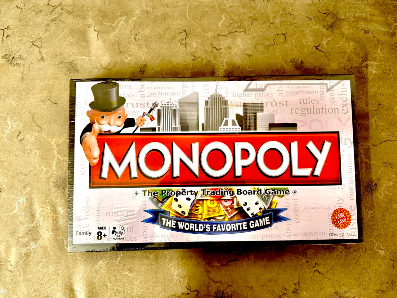 Monopoly board game box on a textured gold background