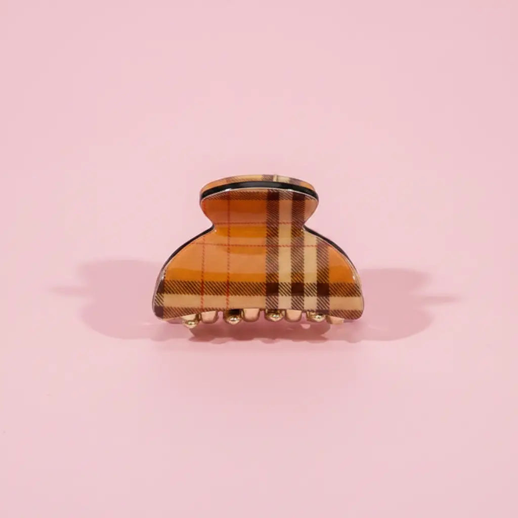 Plaid patterned hair clip on a pink background