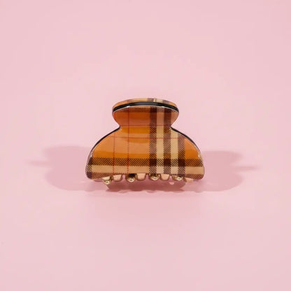 Plaid patterned hair clip on a pink background