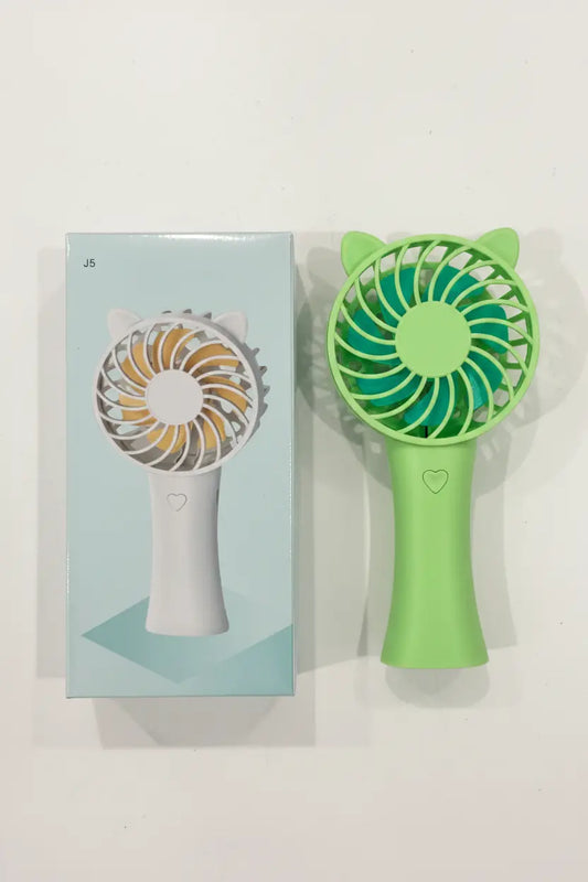 Green handheld fan with cat ear design next to its packaging on a white background