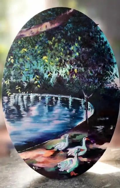 An oval-shaped painting depicting a serene lakeside scene with two white ducks in the foreground, a tree and dense foliage reflected in the blue water, and a dark background.