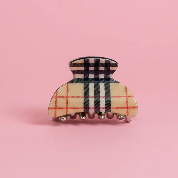 Plaid patterned hair clip on a pink background