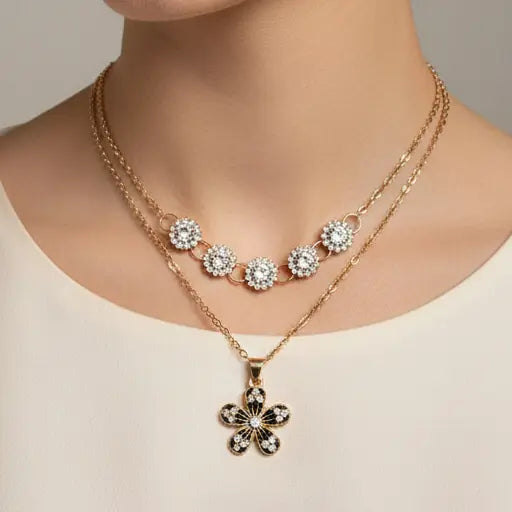 Gold necklace with floral pendant on a neutral background