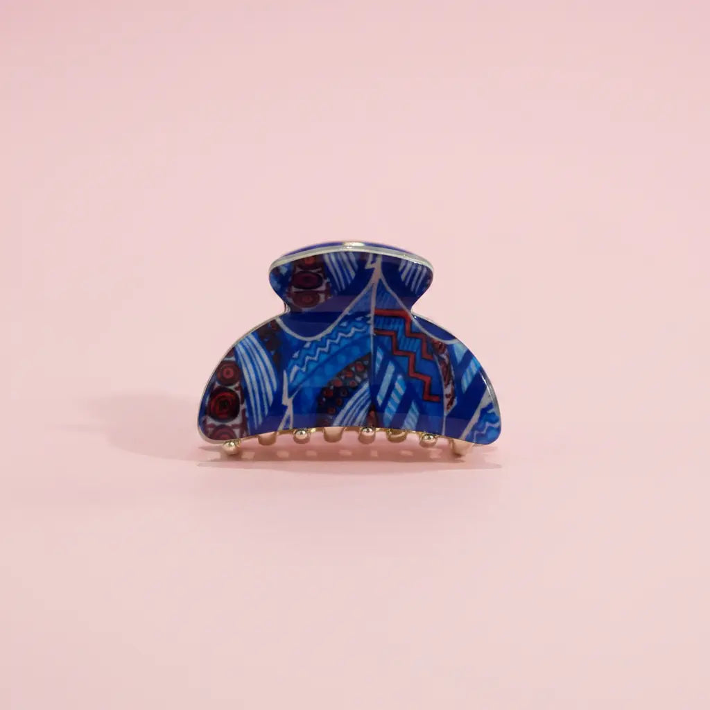 Blue patterned hair clip on a pink background
