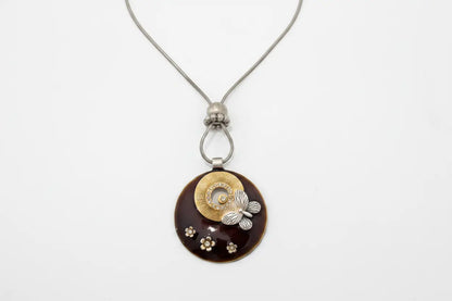 Necklace with a round pendant featuring paw prints and a butterfly on a white background