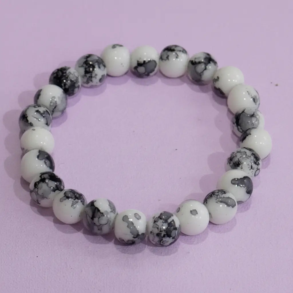 Beaded bracelet with white and gray marbled beads on a pink background