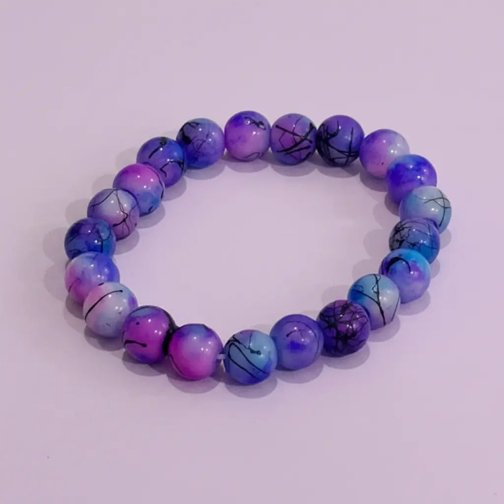 Purple and blue beaded bracelet on a light purple background
