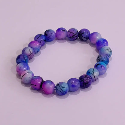 Purple and blue beaded bracelet on a light purple background