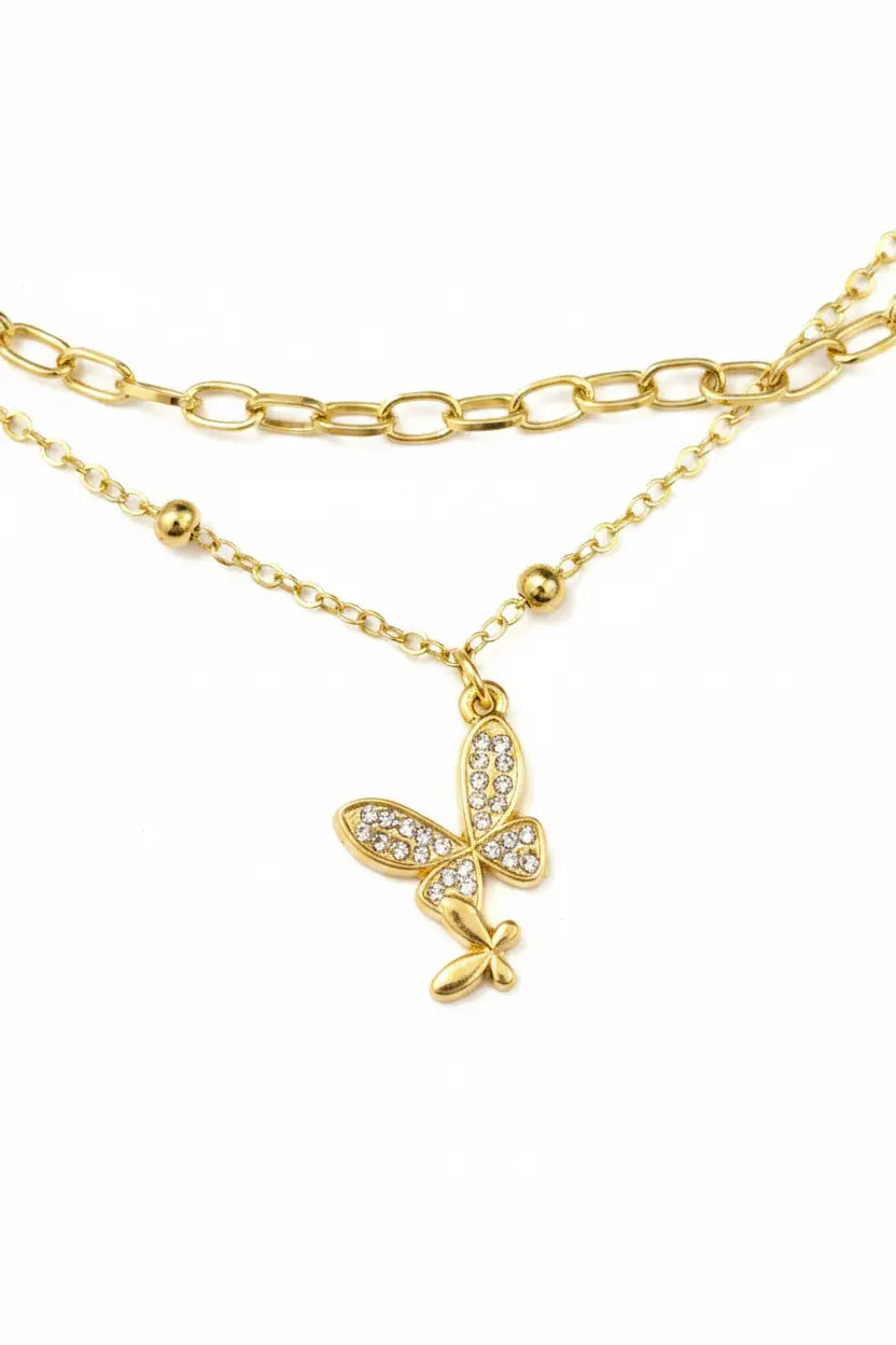 Gold butterfly necklace with clear stones on a white background