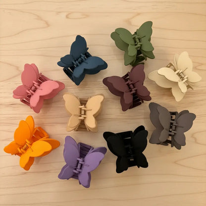 Butterfly-shaped hair clips in various colors on a wooden surface