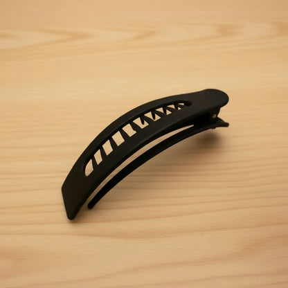 Black hair clip on a wooden surface