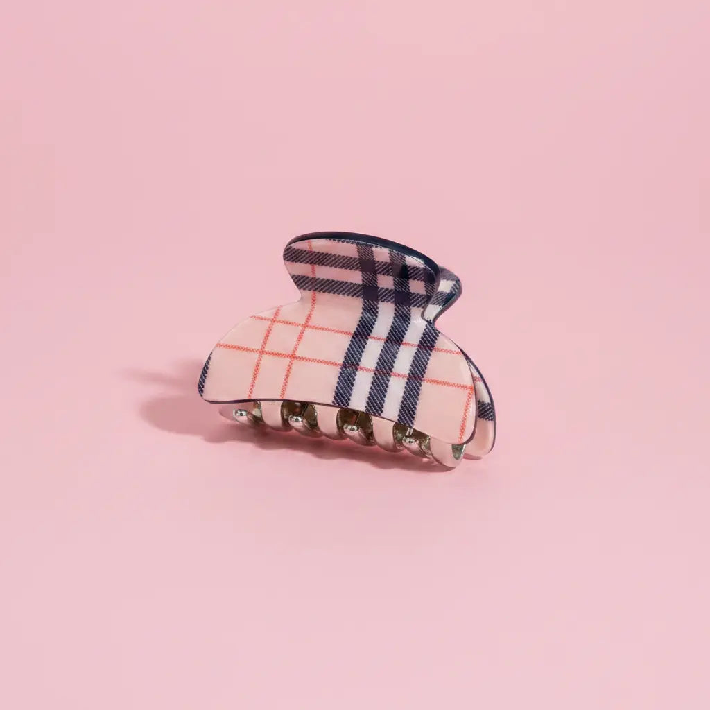 Plaid patterned hair clip on a pink background