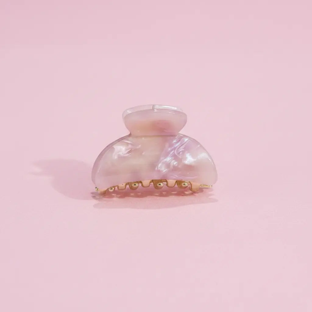 Iridescent hair clip on a pink background