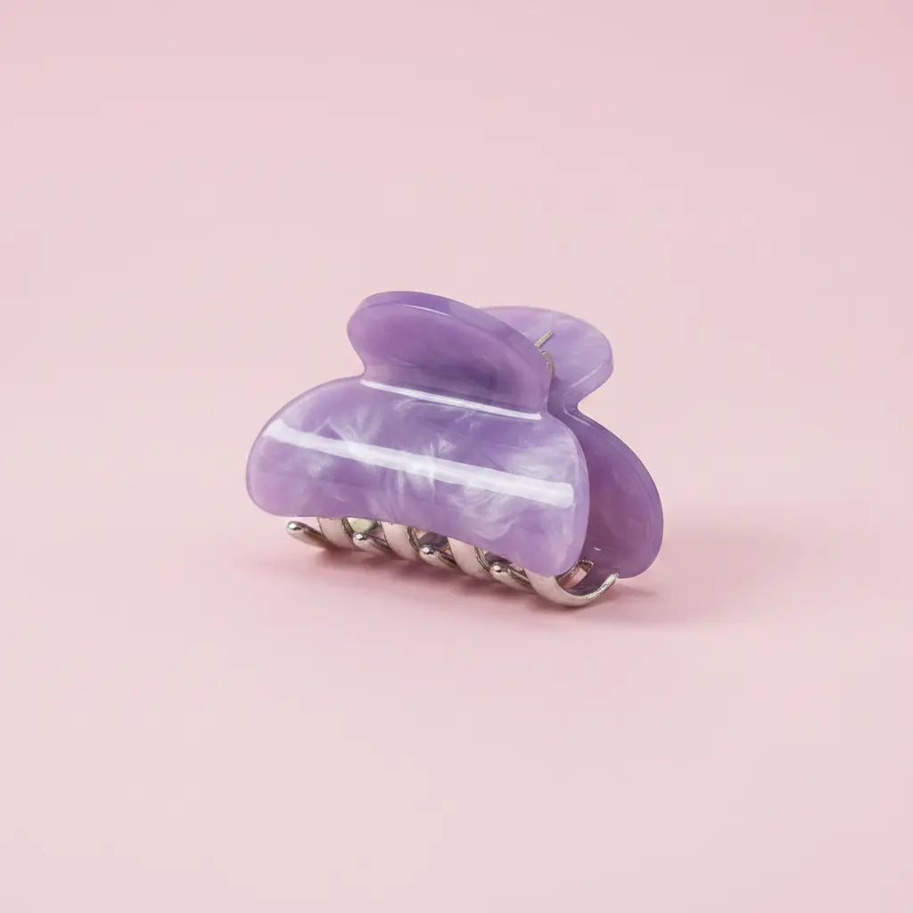 Purple hair clip on a pink background