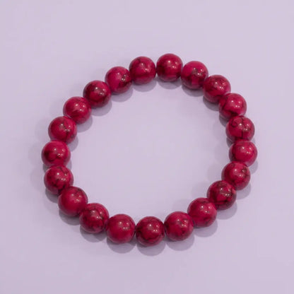 Red beaded bracelet on a light purple background