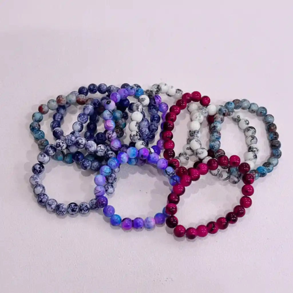 Set of beaded bracelets in various colors on a light background