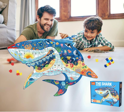 Man and child playing with a shark-shaped puzzle in a living room.