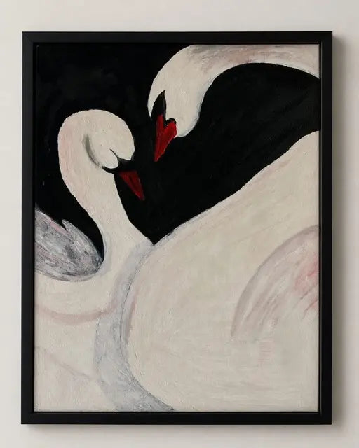 Framed art print depicting two swans with contrasting black and off-white bodies and bright red beaks, set against a dark background.