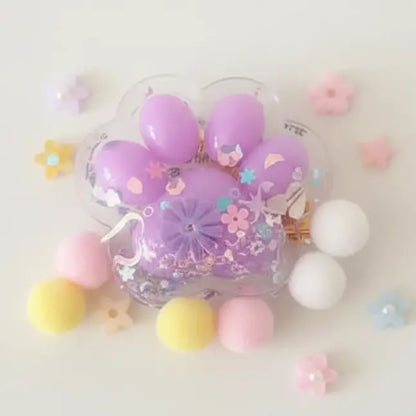 Decorative phone case with purple paw print design surrounded by colorful beads on a light background