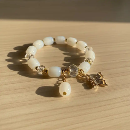Beaded bracelet with a butterfly charm on a wooden surface