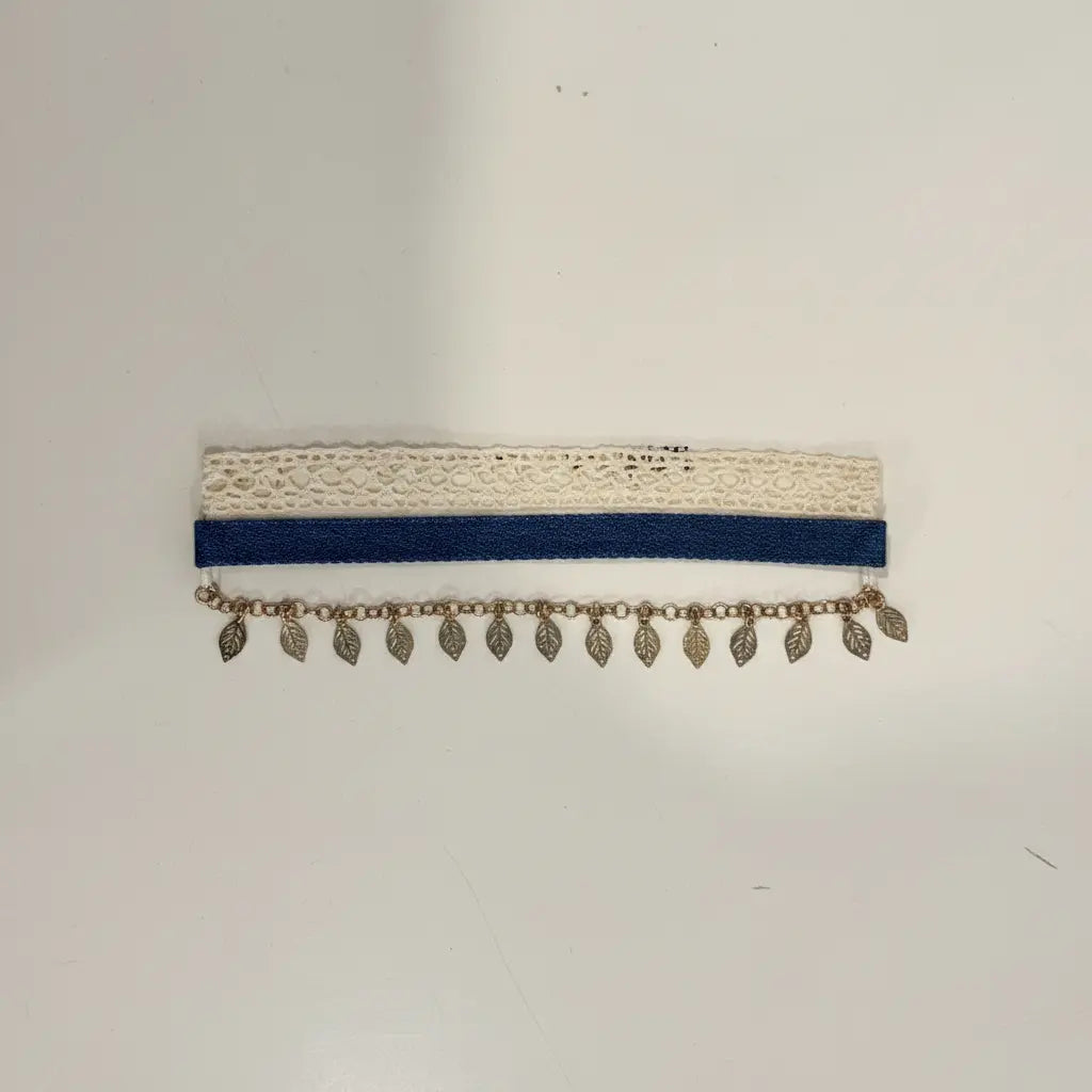 Necklace with blue band and leaf-shaped pendants on a white background